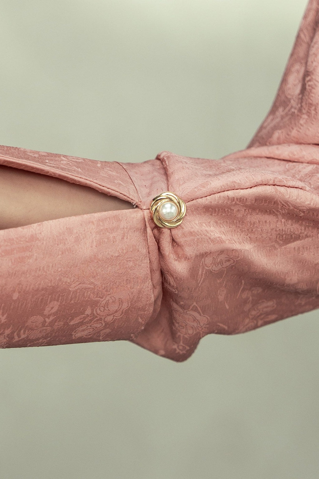 The Blush cuff up close, showing the crinkled georgette and the pearl button.