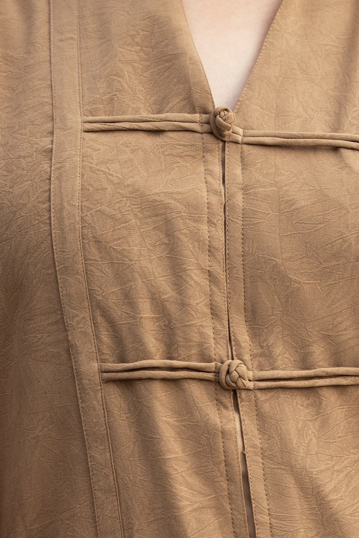 The Dune georgette up close, showing the weave and the hand-knotted frog buttons.