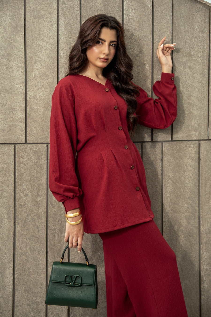 Ruby maroon co-ord against a stone wall.