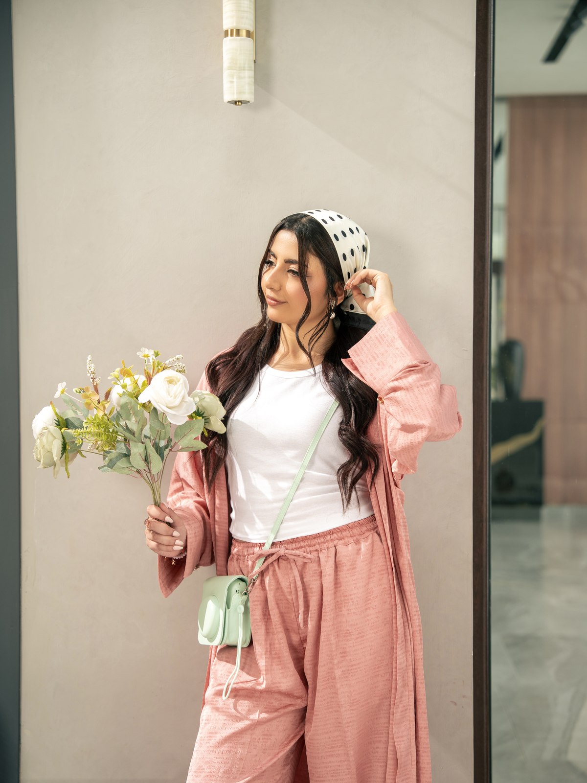 The Blush kimono worn open, holding a posy of flowers.