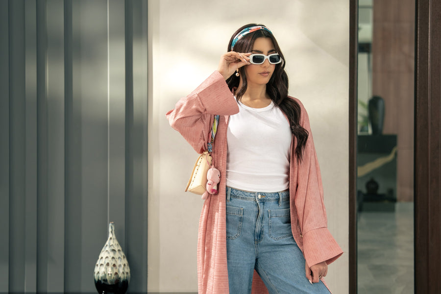 The Blush kimono worn open over jeans, beside the mirrored wall.